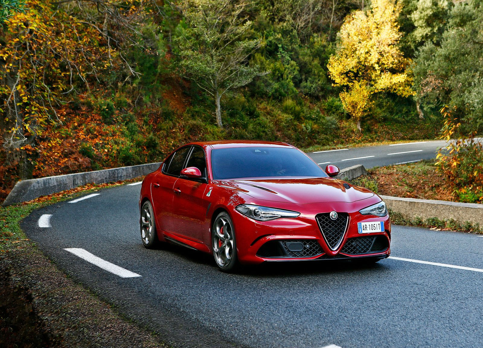 Alfa Romeo Giulia Quadrifoglio vermelho fazendo curva na estrada