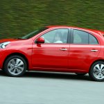 Nissan March CVT na cor vermelha de perfil em movimento na rua