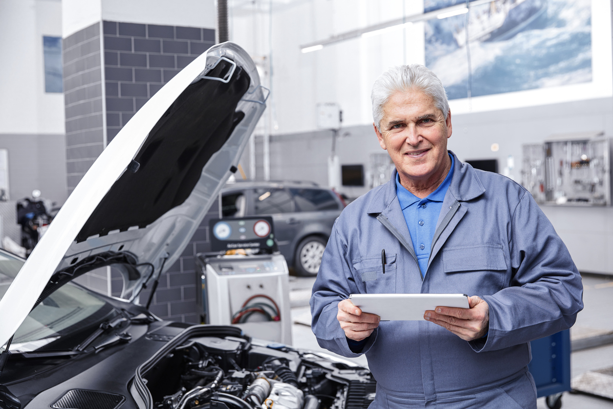 Auto Mechanic Working On A Car Engine In Repair Shop.
