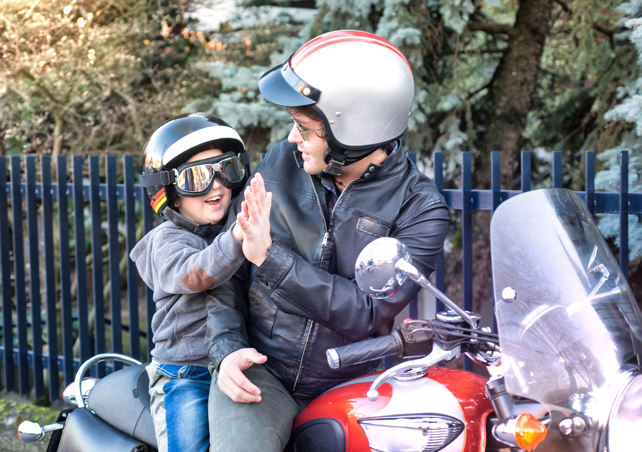 Dad And Son Giving A Five Riding A Motorcycle