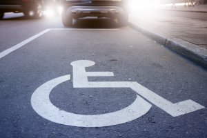 Comprar veículo pcd: símbolo de pessoas com deficiência em vaga de carro na rua