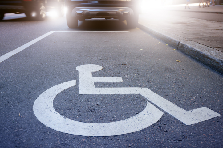 Comprar veículo pcd: símbolo de pessoas com deficiência em vaga de carro na rua