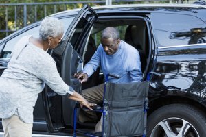 Comprar carro pcd: homem com deficiência sai do carro no banco do passaeiro