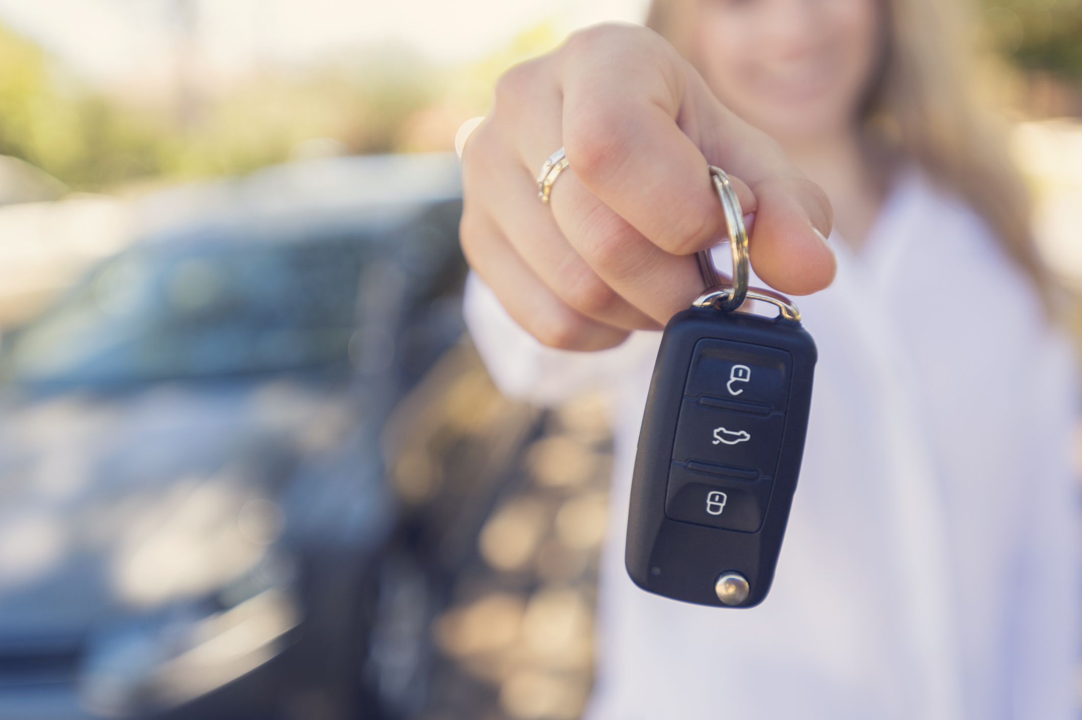 Female Car Salesperson Handing Over The New Car Keys