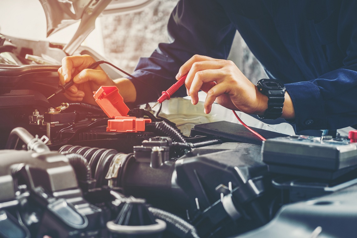 Auto Mechanic Checking Car Battery Voltage