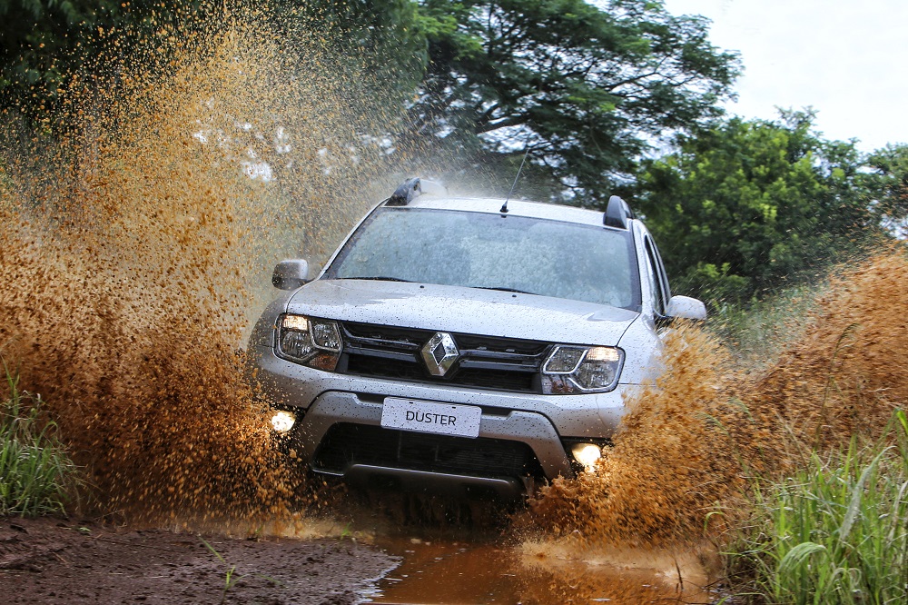Novo Renault Duster 2016de frente na cor prata levanta a´gua com lama ao passar por trecho de estrada de terra