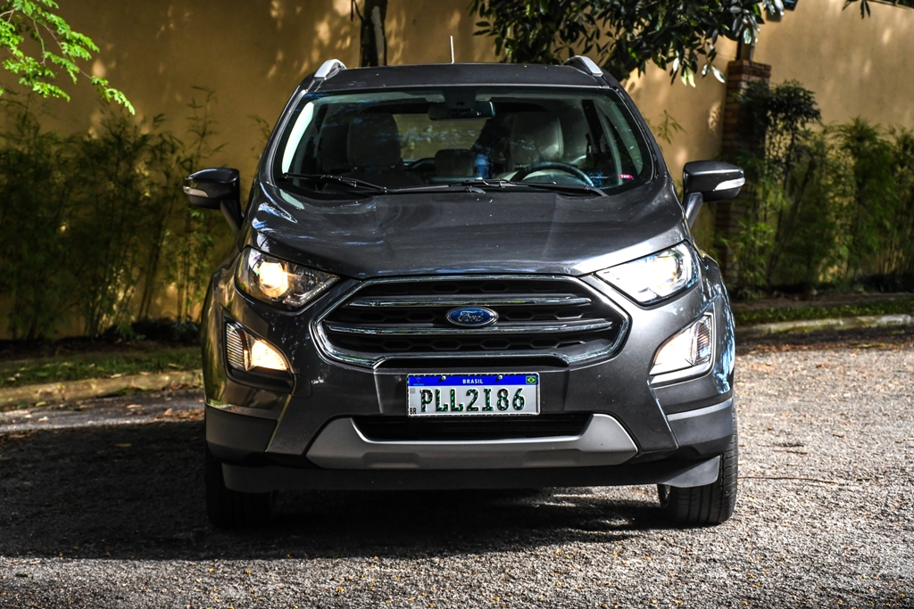 Ford EcoSport Titanium na cor cinza escuro de frente e com os faróis e luzes de neblina ligados