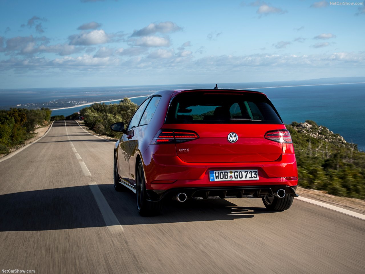 Volkswagen Golf GTI vermelho na estrada asfaltada e com céu azul ao fundo