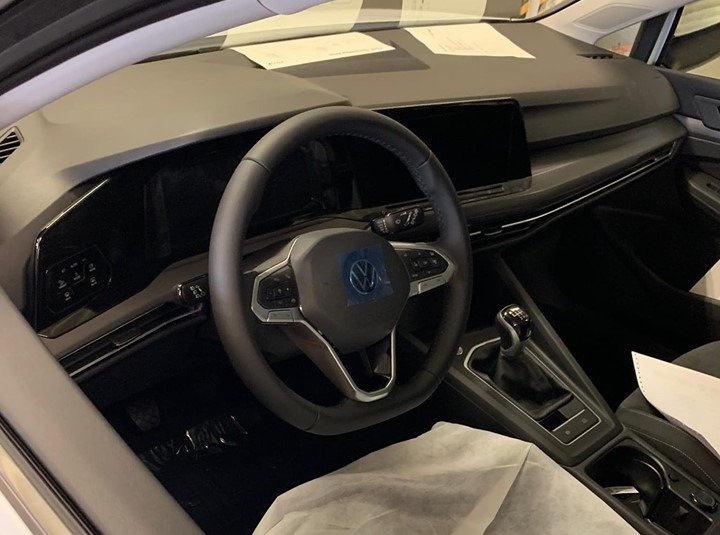Cabine do Volkswagen Golf de oitava geração mostra volante igual ao do SUV ATlas, bancos cobertos, painel com muito plástico e centrl multimídia grande