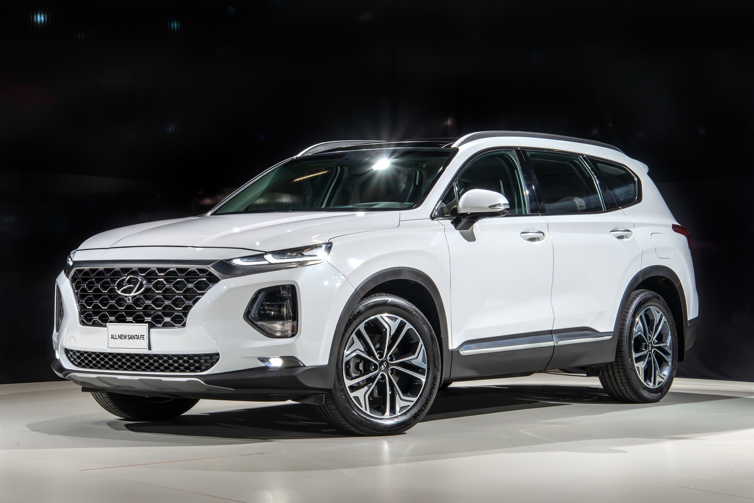 Novo Hyundai Santa Fe branco larga grade cromada em cascata na dianteira e uma composição de luzes em LED