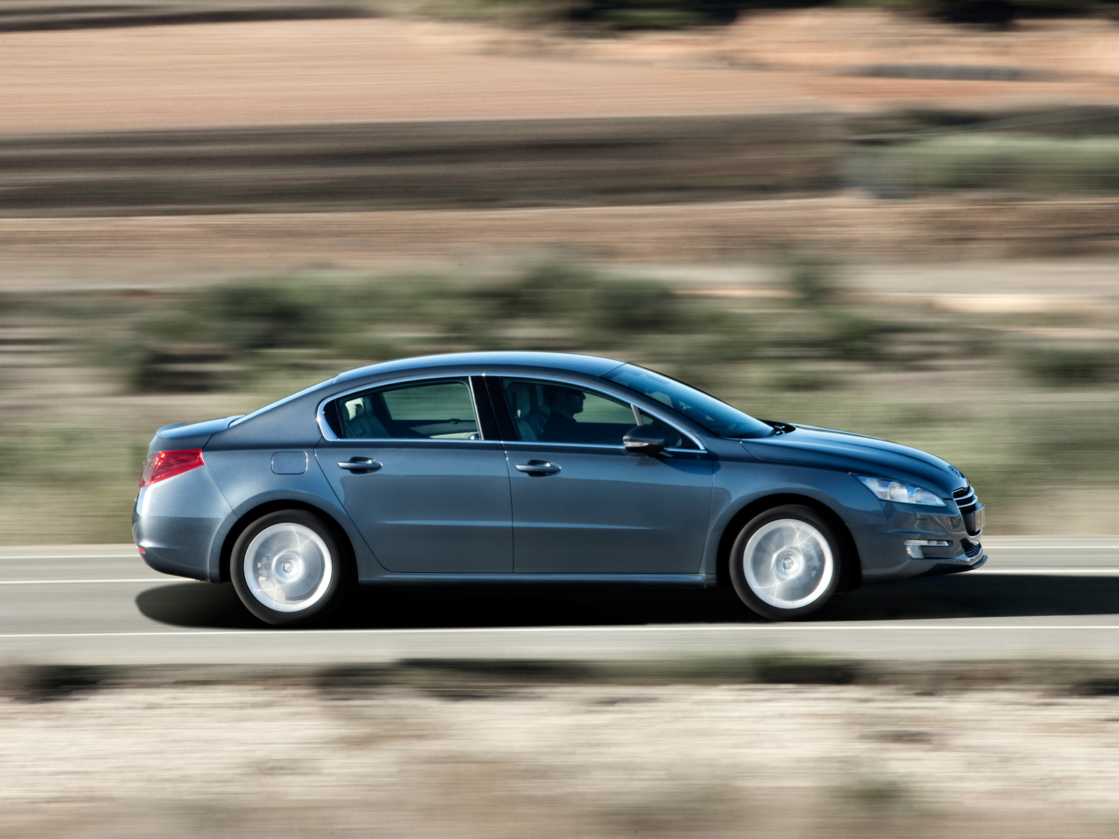 Peugeot 508 cinza escuro em movimento na estrada