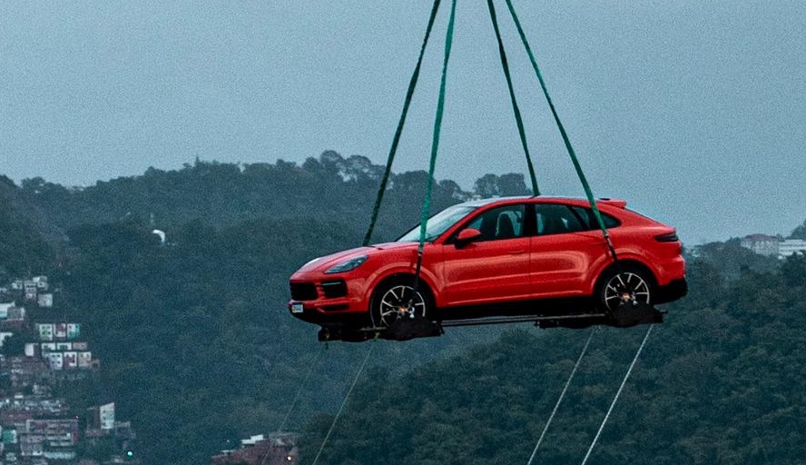 Cayenne Coupé laranja içado por helicóptero