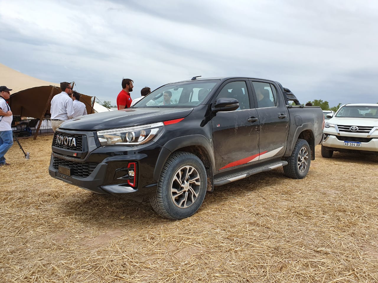 Toyota Hilux GR2 preta com detalhes vermelhor aparece em pista de areia na Argentina