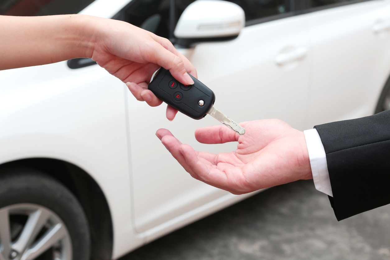 Homem enrega chave a comprador do seu carro