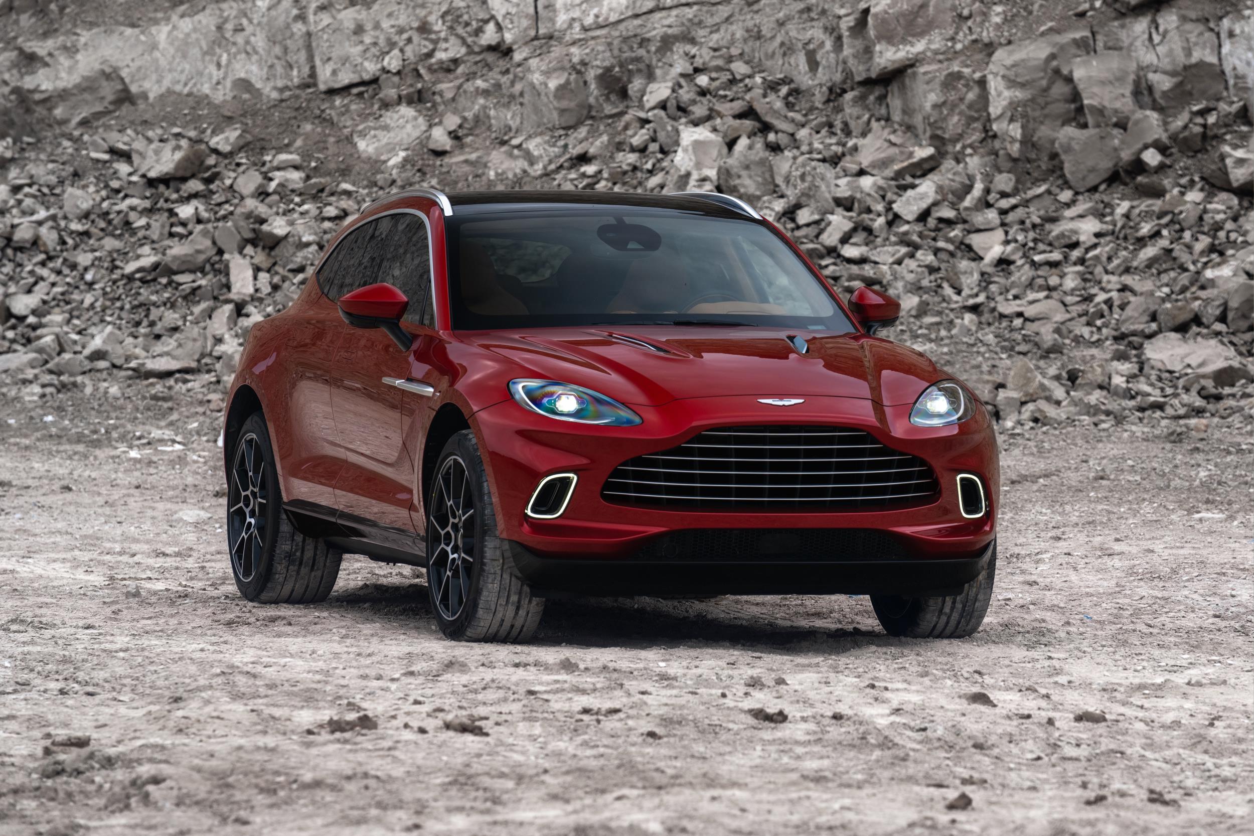 Aston Martin DBX na cor vinho de frente em uma pedreira