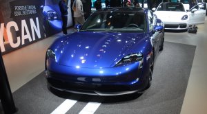 Porsche Taycan 4s azul de frente no estande da marca no Salão de Los Angeles