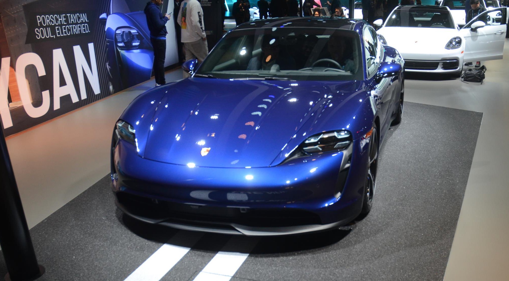 Porsche Taycan 4s azul de frente no estande da marca no Salão de Los Angeles