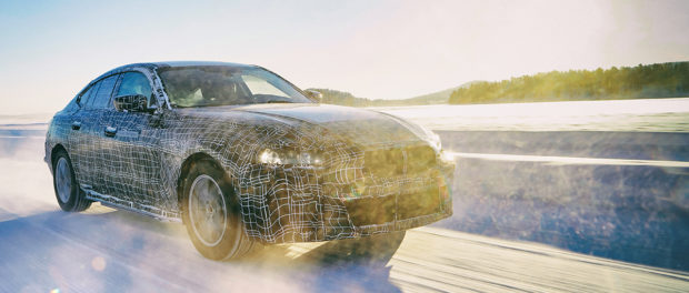 BMW i4 em teste camuflado na neve com o sol a contra-luz