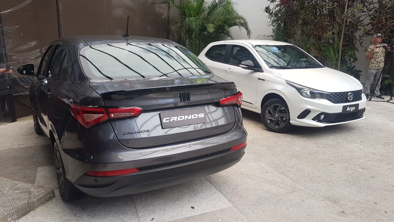 Fiat Cronos preto de traseira e Fiat Argo branco de frente, lado a lado