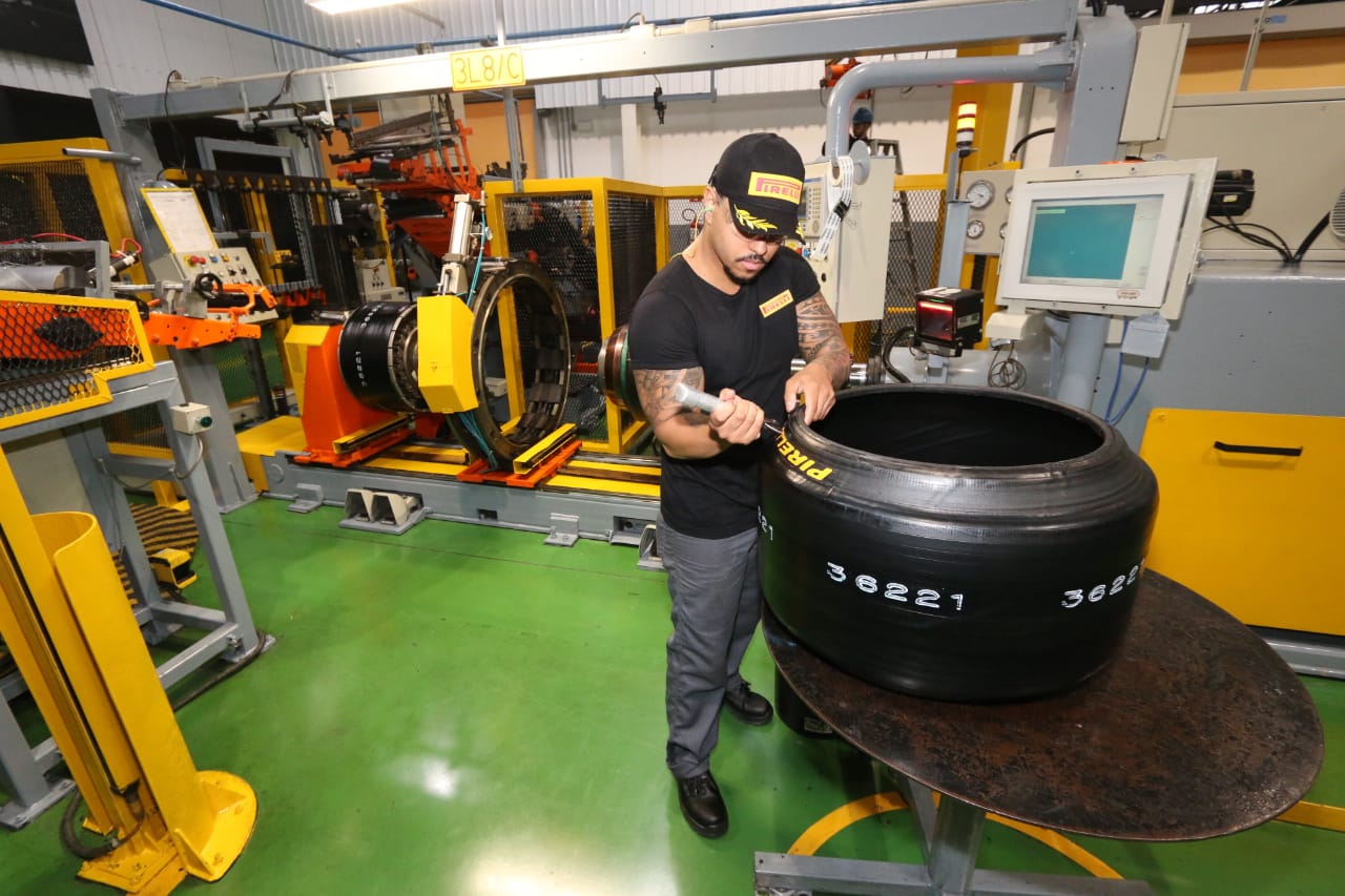 Funcionário da Pirelli na linha de montagem de um pneu de competição