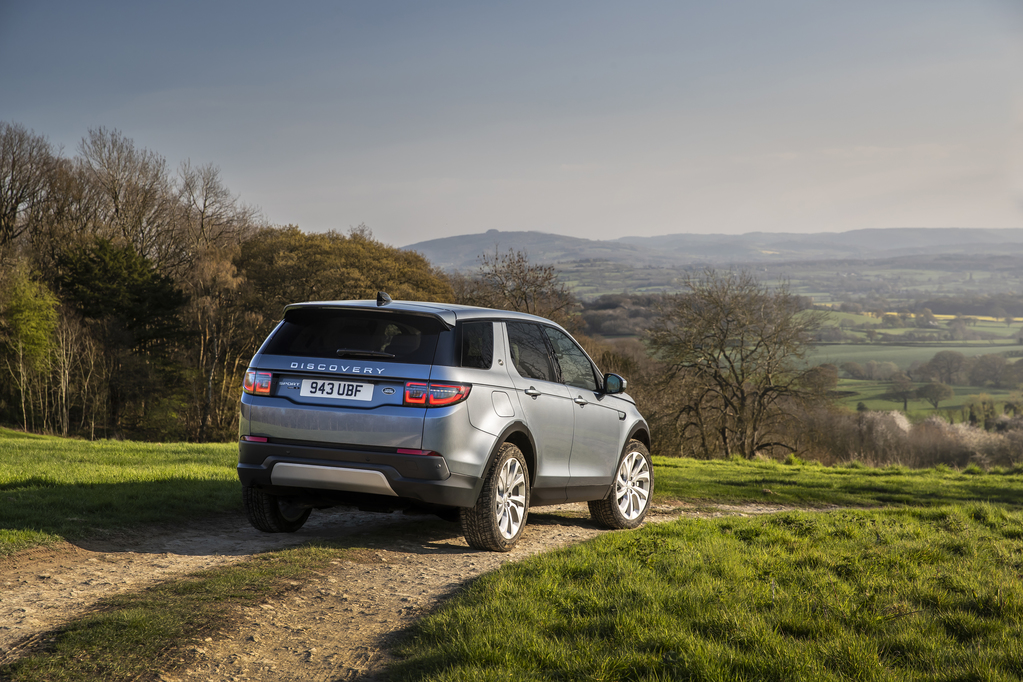 Land Rover Discovery Sport de traseira na cor cinza com lanternas que invadem as laterais e contornos levemente aredondados