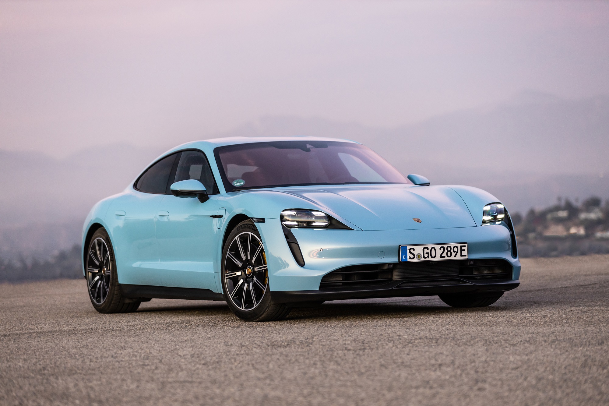 Porsche Taycan 4s na cor azul clara de frente em um deserto