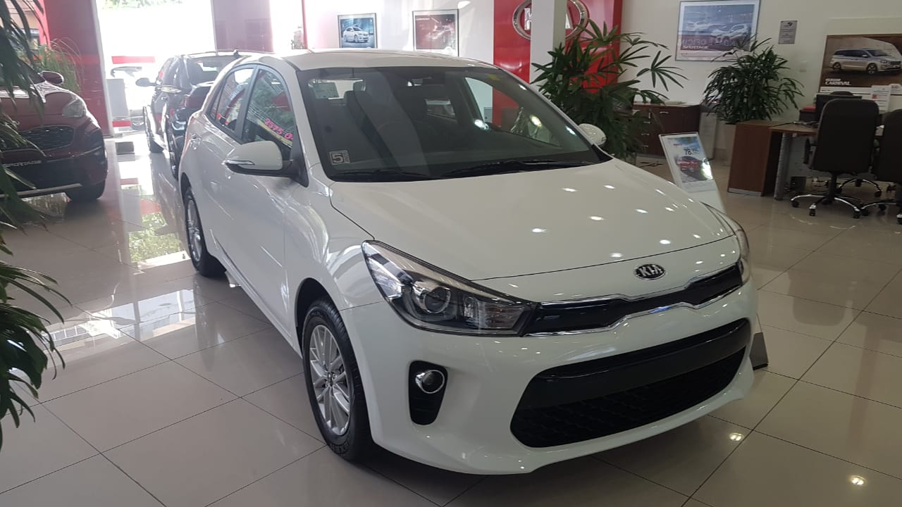 Kia Rio Ex branco de frente exposto em concessionária da marca