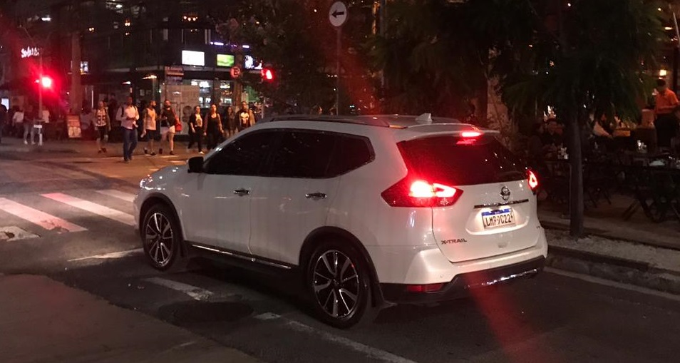Nissan X Trail branco parado em semáforo em uma rua de São Paulo à noite