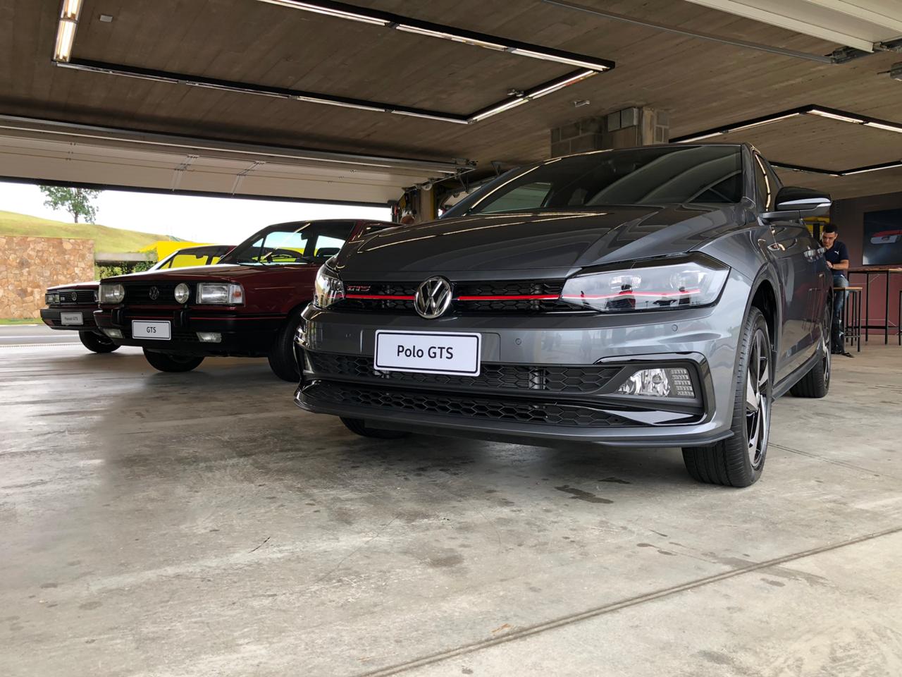 Volkswagen Polo GTS na cor cinza metálica em uma garagem ao lado de um Gol GTS dos anos 1980