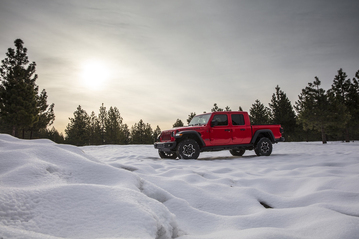 Jeep Gladiator vermelha de perfil no meio da neve