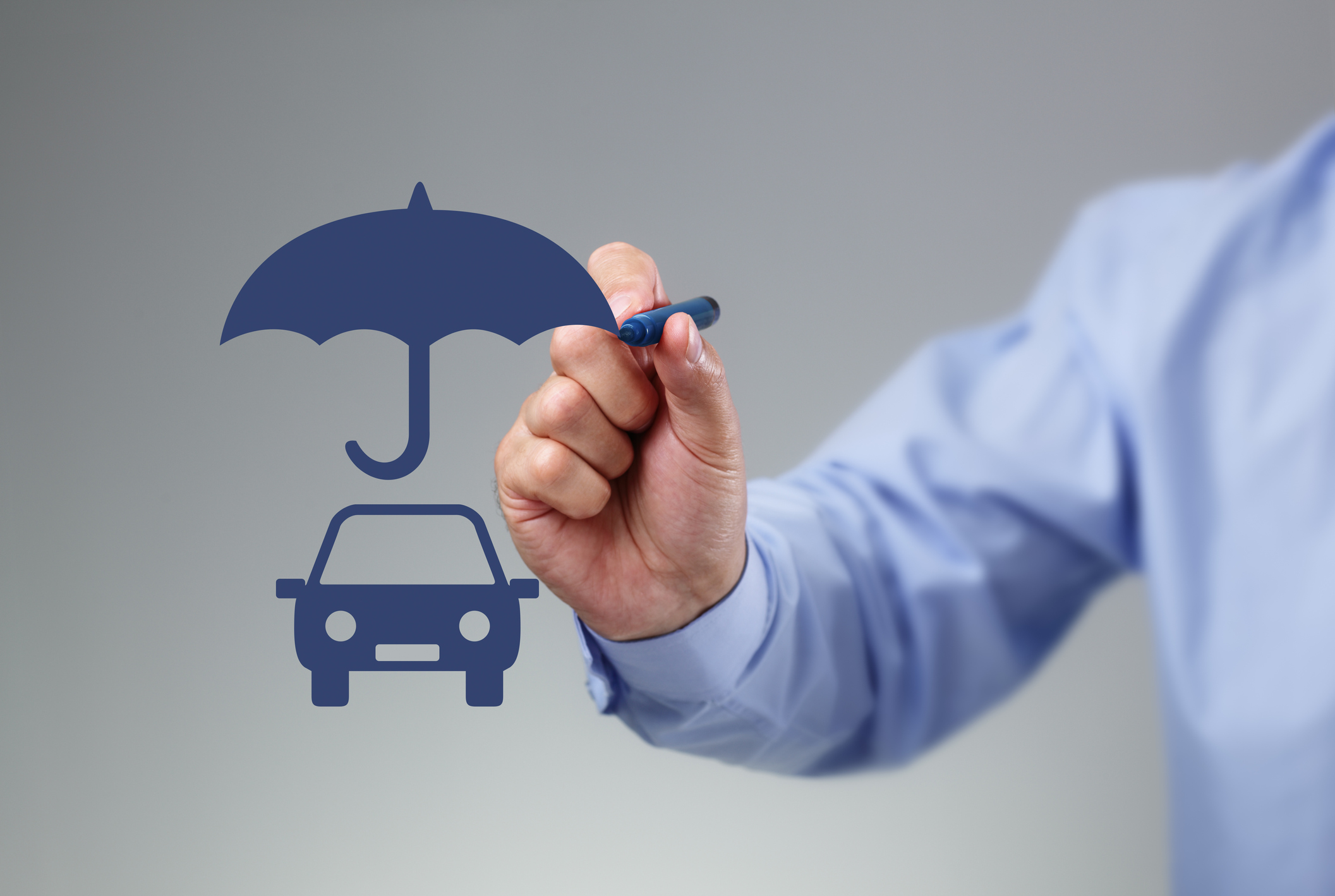Homem desenha um carro com caneta azul coberto por um guarda-chuva