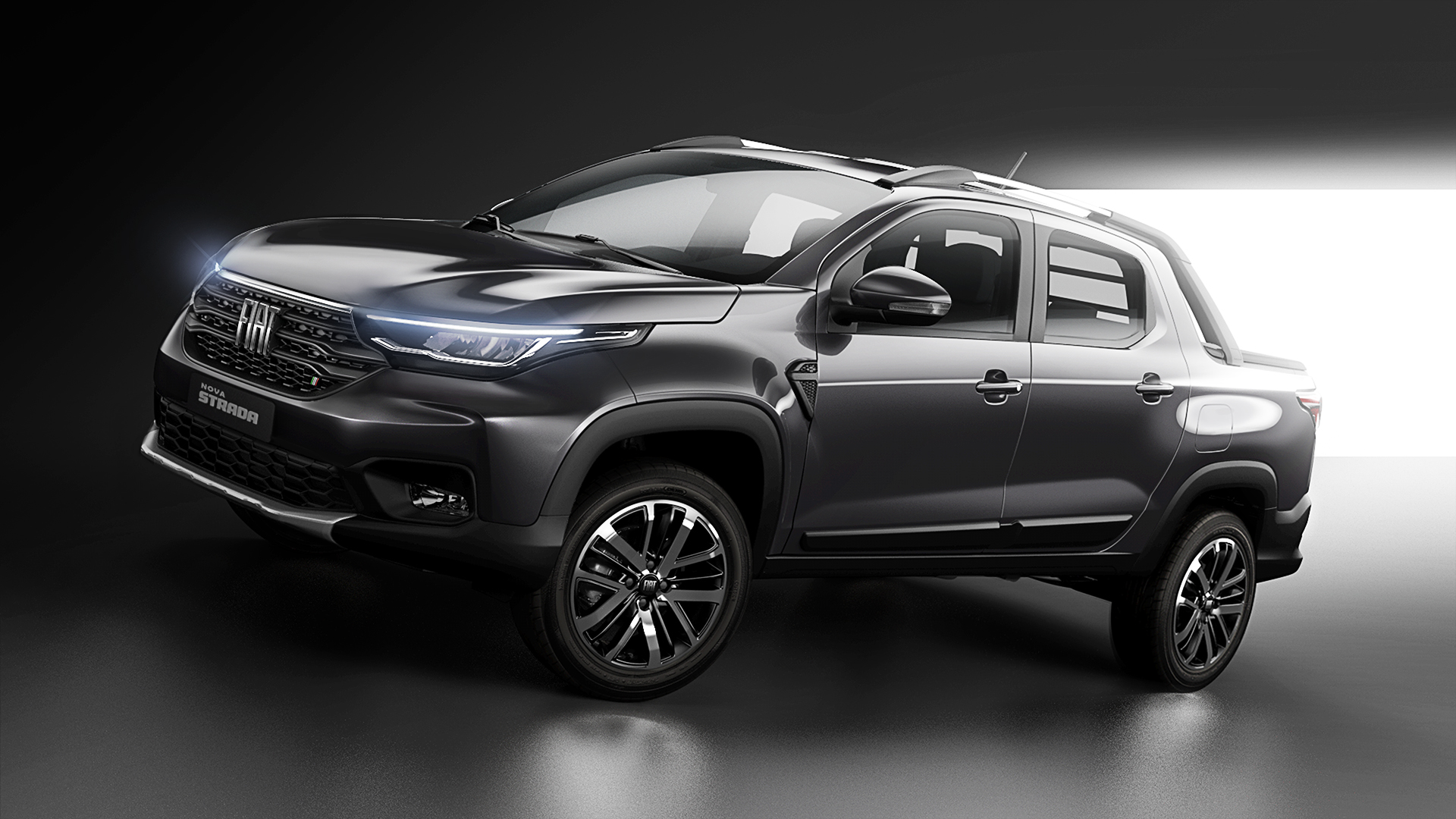 Nova Fiat Strada na cor cinza escuro de perfil em foto de estúdio