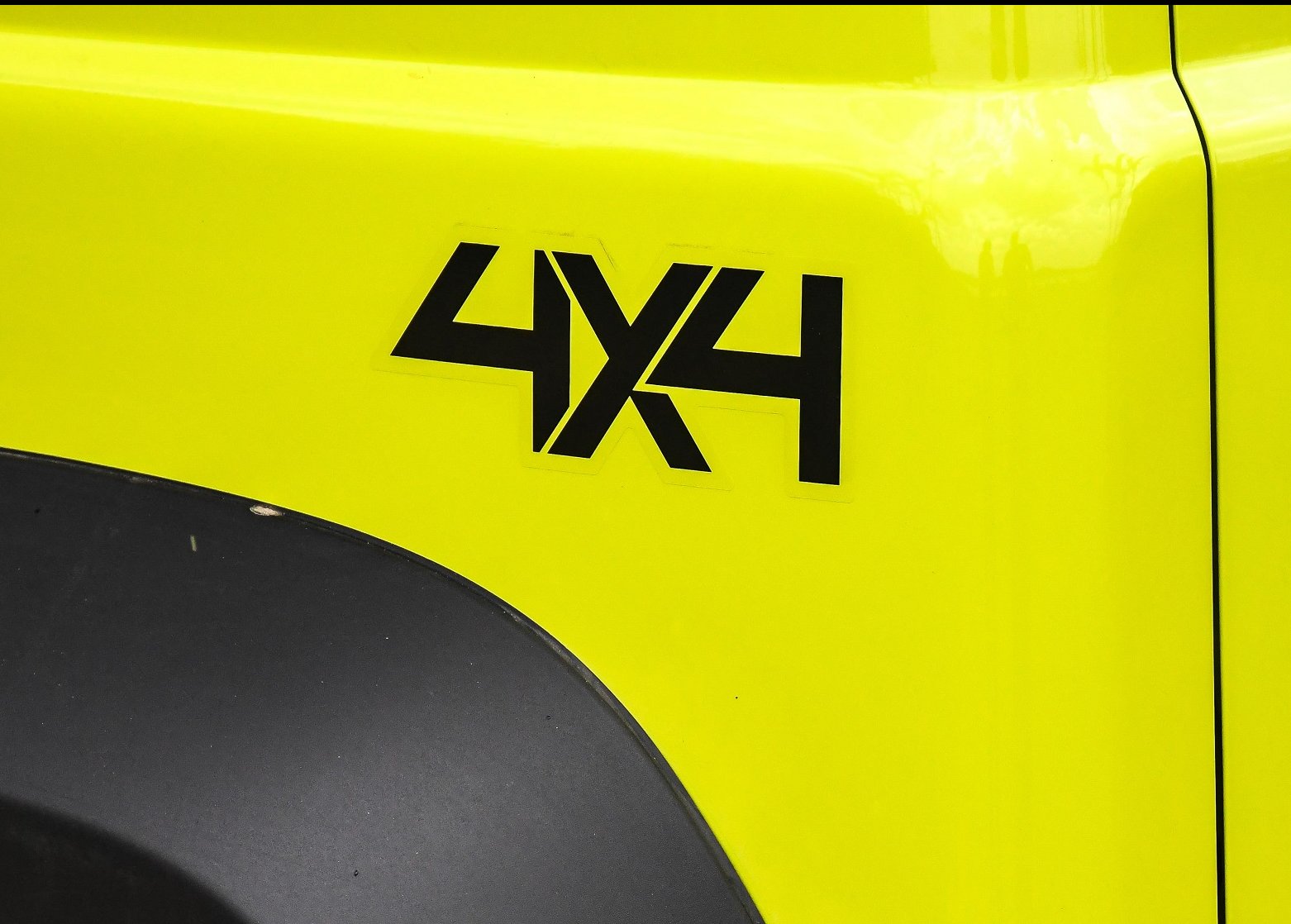 Emblema 4x4 perto do para-mlama traseiro do Jimny verde