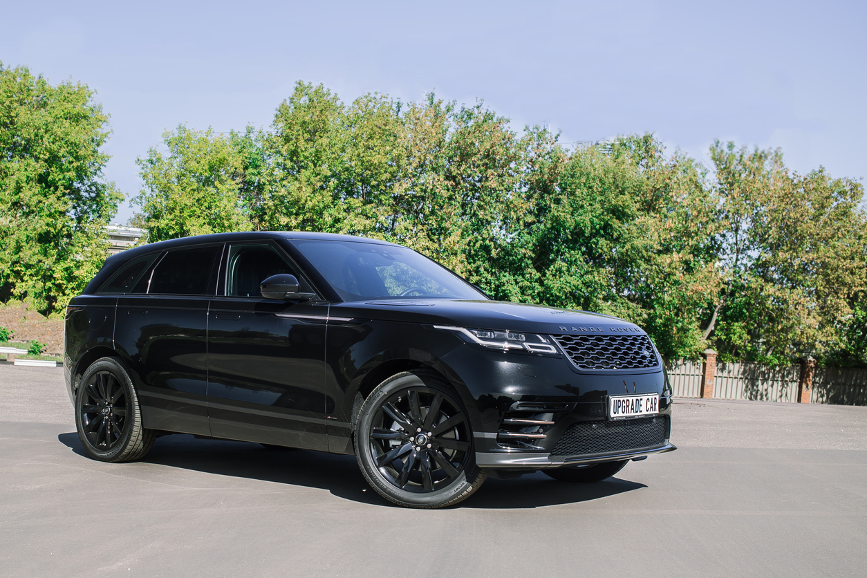 Land Rover Range Rover Velar preta ambientada na estrada com árvores no plano de fundo