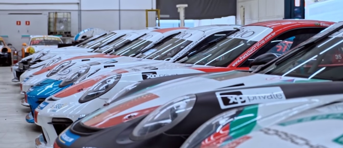 Carros de competição da Porsche Cup perfilados na oficina