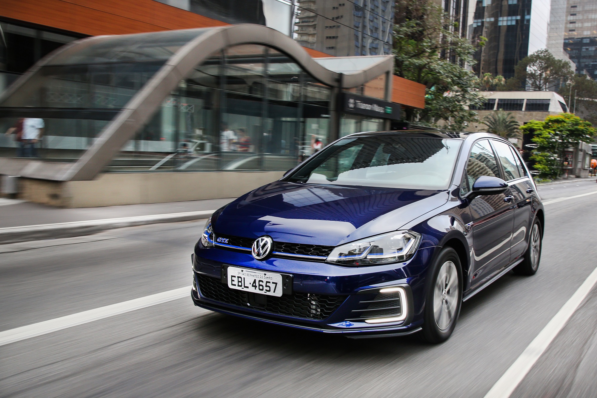 Volkswagen Golf Gte azul escuto em movimento na rua com detalhe azul claro na grade dianteira e a inscrição GTE
