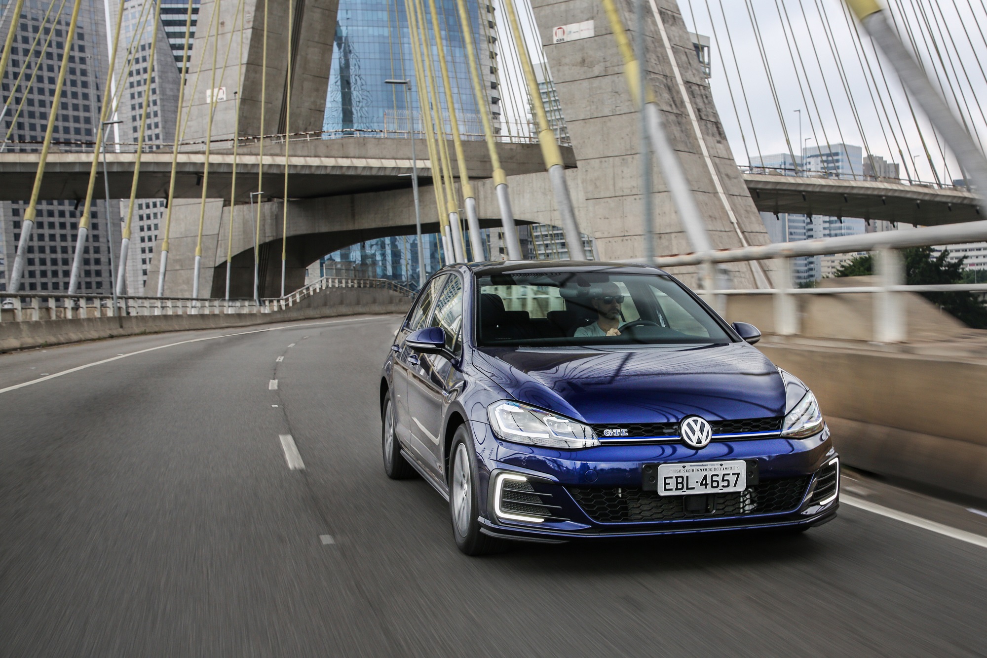 Volkswagen Golf Gte azul fazendo curva em uma ponte estaiada