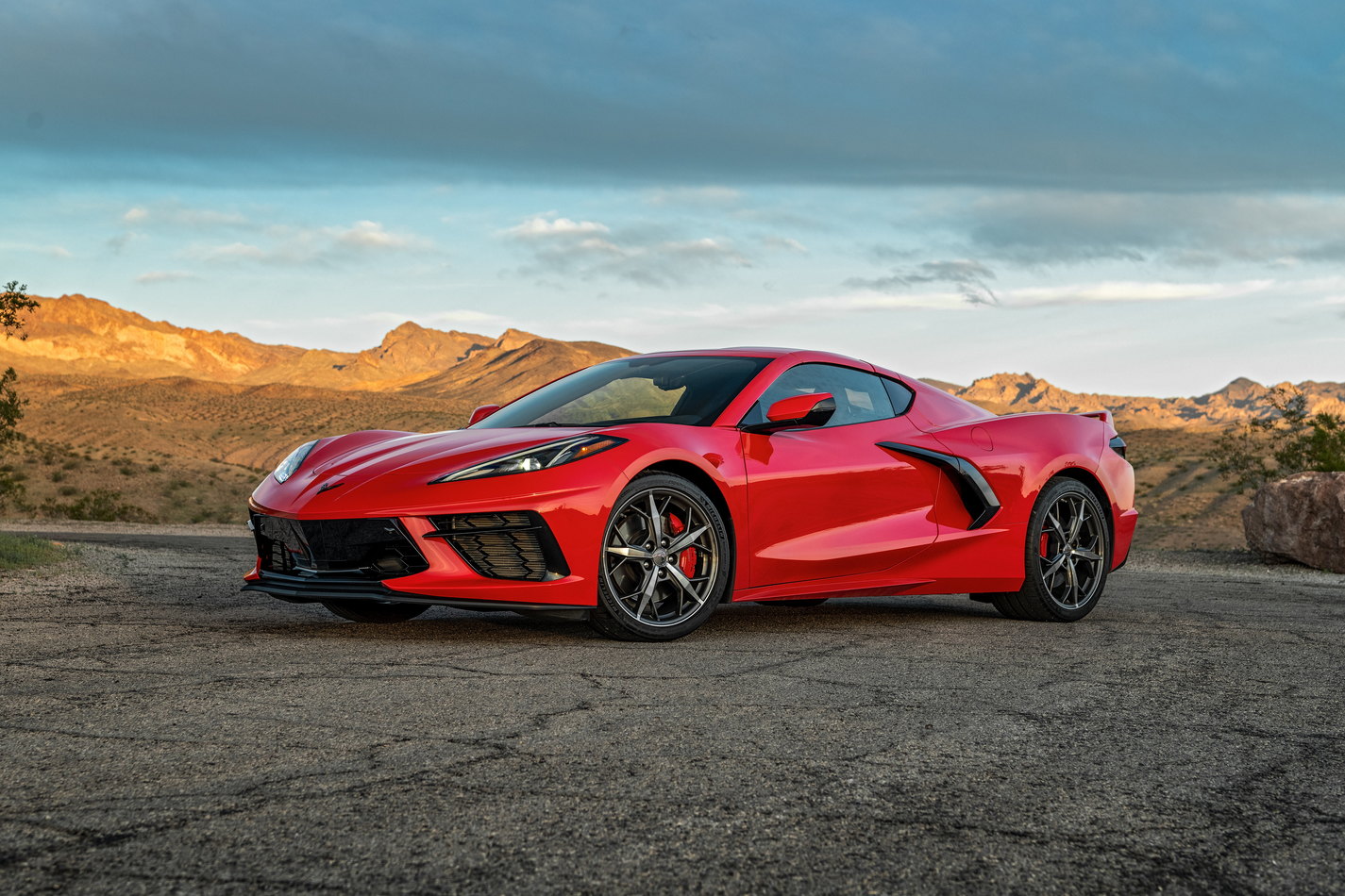 Chevrolet Corvette 2020 vermelho no alto de um penhasco com rochas e deserto ao fundo