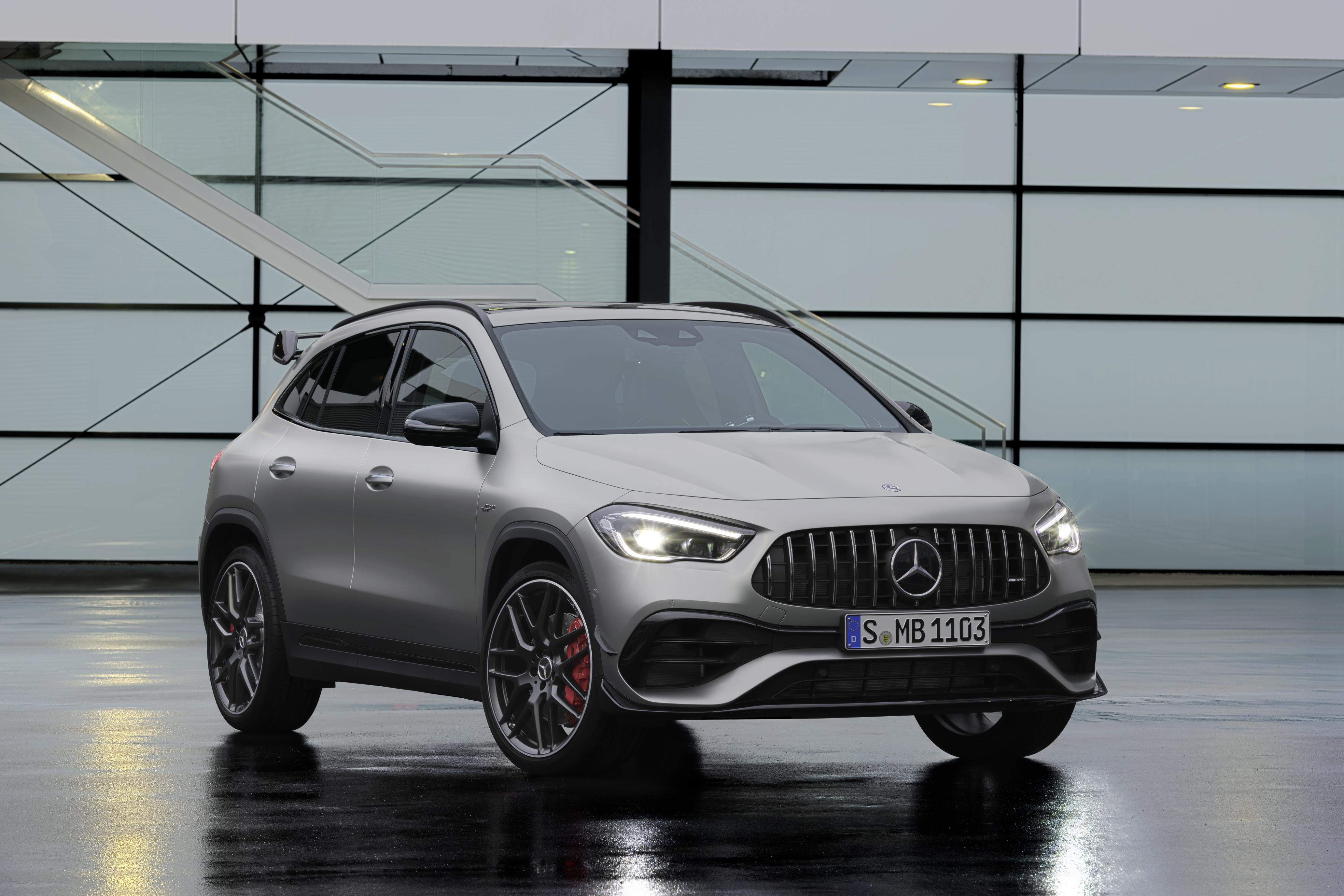 Mercedes Benz Gla 45 4matic de frente na cor prata em um estúdio com, janelas retangulares ao fundo