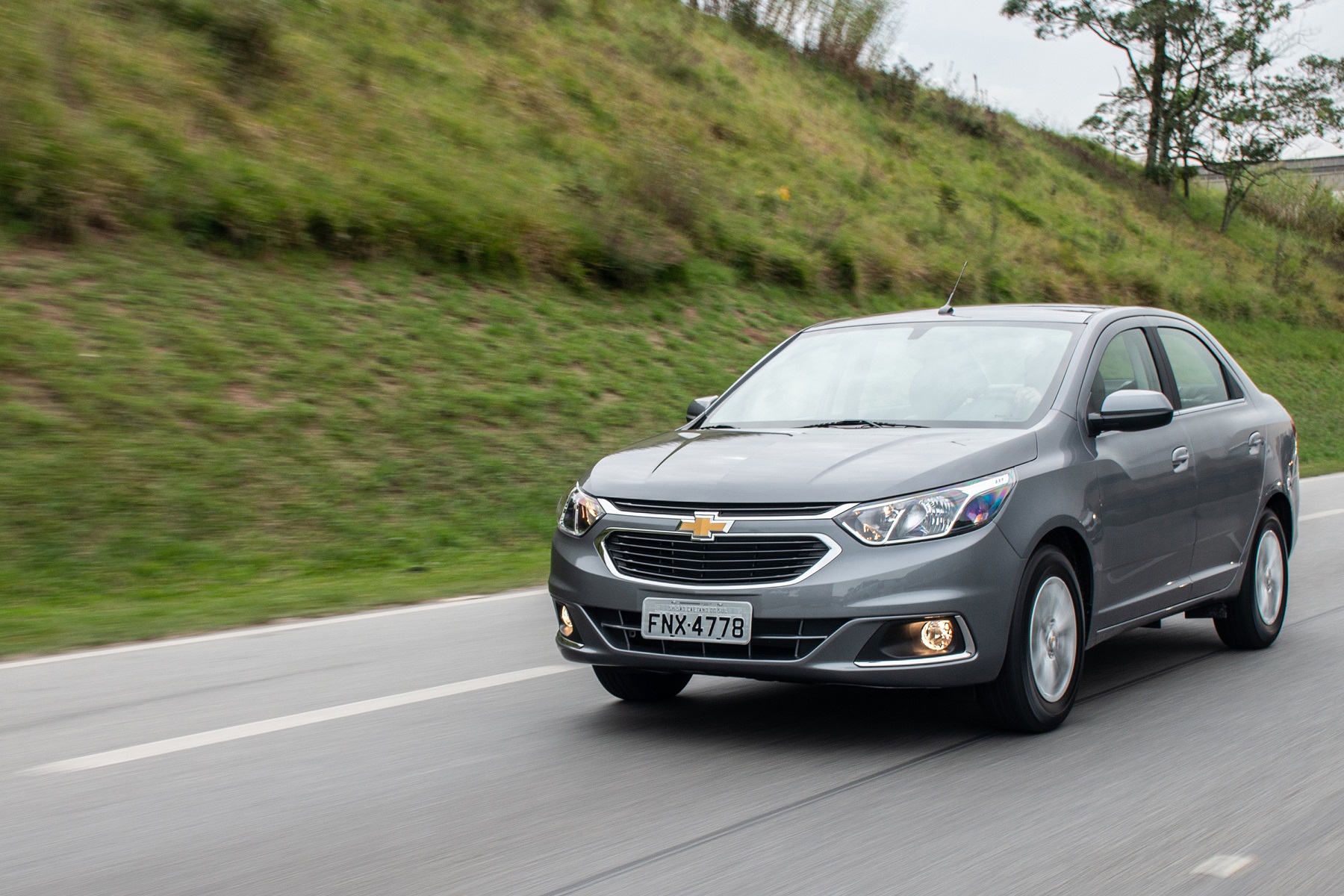 Chevrolet Cobalt prata escuro em movimento numa rodovia