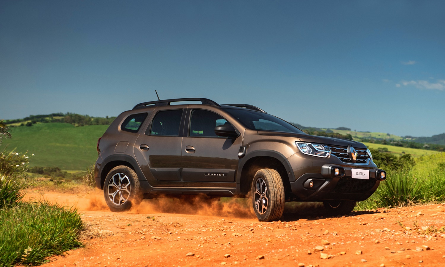 Novo Renault Duster 202marrom metálico fazendo uma curva em uma estrada de terra1