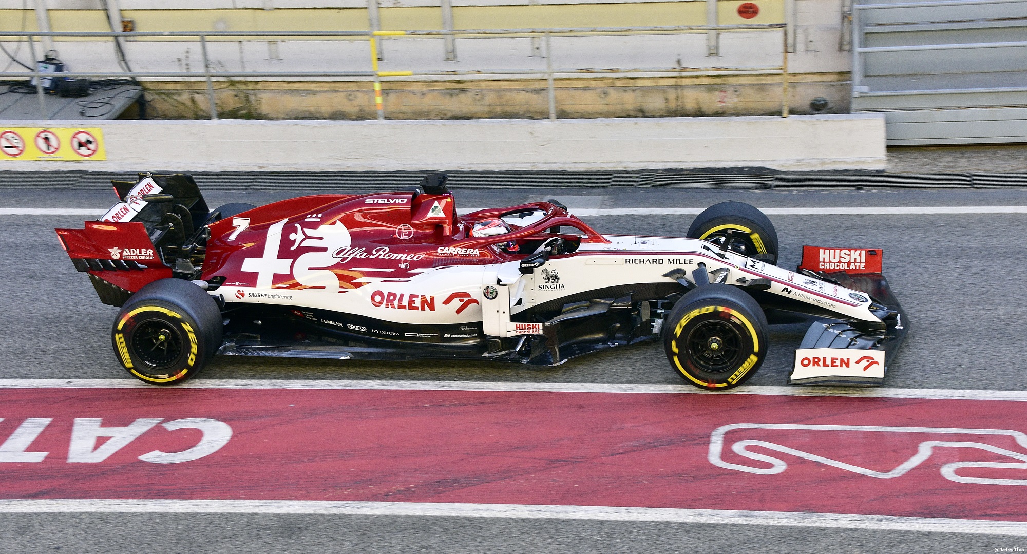 Carro de fórmula 1 da Alfa Romeo visto de cima e de perfil na reta dos boxes do circuito