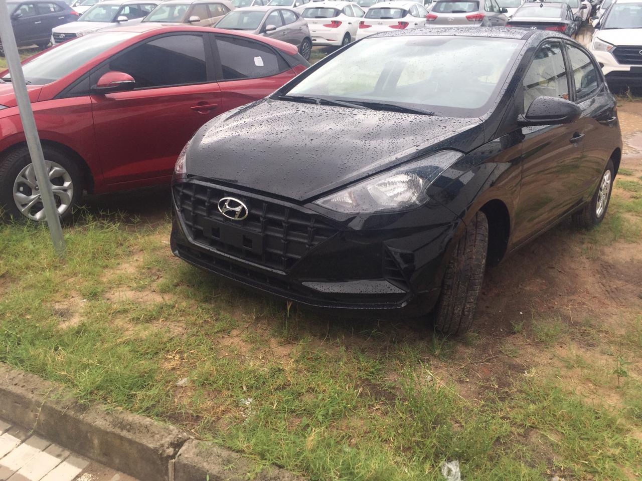 Hyundai Hb20 estacionado em um pátio gramado com grade preta