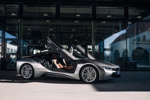 BMW i8 em uma garagem parcialmente iluniada com as portas tipo tesoura levantadas