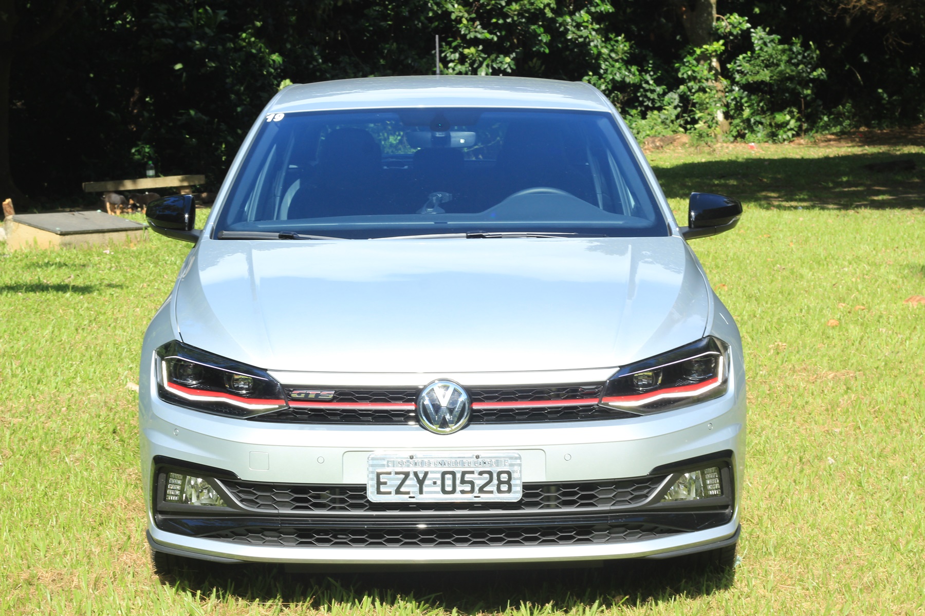 Volkswagen Polo GTS de frente em gramado com árvores ao fundo