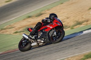 Bmw S 1000 Rr vermelha fazendo uma curva inclinada na pista