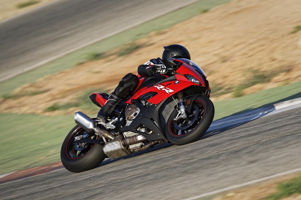Bmw S 1000 Rr vermelha fazendo uma curva inclinada na pista