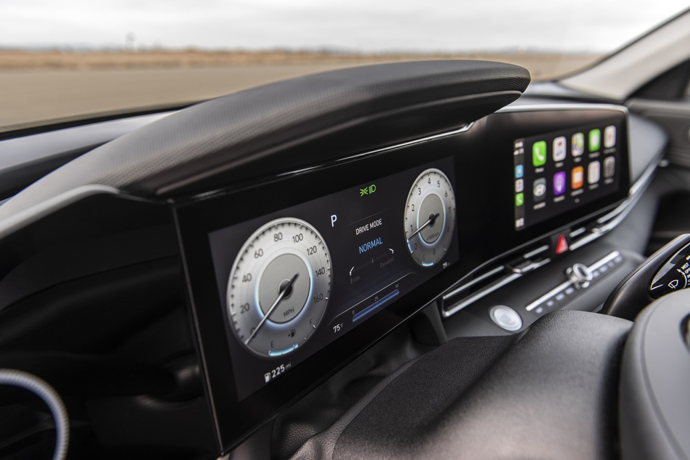 Foto mostra a tela do quadro de instrumentos configurada para velocímetro e conta-giros redondos em forma analógica e ao lado a tela da central multimídia
