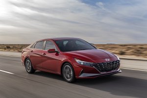 Novo Hyundai Elantra na cor vermelha em movimento na estrada ao fundo paisagem de deserto