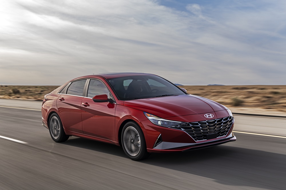 Novo Hyundai Elantra na cor vermelha em movimento na estrada ao fundo paisagem de deserto